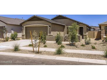 Charming single-story home featuring a two-car garage, desert landscaping, and a welcoming entryway at 15018 W Buckskin Trl, Surprise, AZ 85387