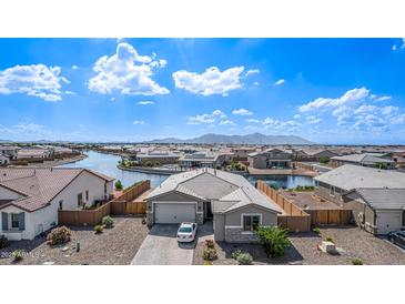 A well-kept single Gathering house with a neat yard and a lake, located in a well-maintained community at 22206 N Daniel Dr, Maricopa, AZ 85138