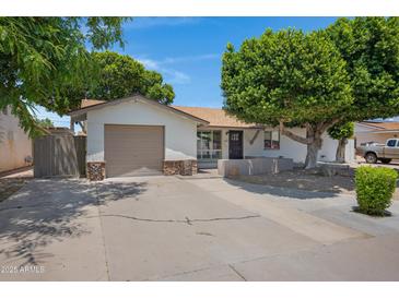Charming single-story home featuring a well-manicured front yard and a convenient attached garage at 2510 W Columbine Dr, Phoenix, AZ 85029