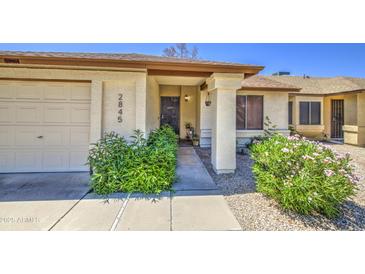 Inviting front entryway with a private two car garage and lush plants at 2845 E Irwin Ave, Mesa, AZ 85204