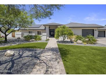 Beautiful home with lush landscaping, stone accents, and a welcoming walkway to the front door at 5926 E Hartford Ave, Scottsdale, AZ 85254