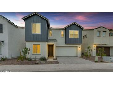 Two-story home featuring a two-car garage, neutral stucco, grey siding, and a well-manicured front yard at 6434 N 17Th St, Phoenix, AZ 85016