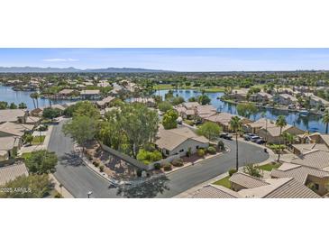 Stunning aerial view of a lakeside home in a scenic neighborhood with lush landscaping and mountain views at 1135 W Sea Fog Dr, Gilbert, AZ 85233