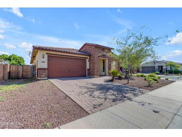 Charming single-story home showcasing a stone facade, a brick driveway, and a well-manicured desert landscape at 18362 W Illini St, Goodyear, AZ 85338