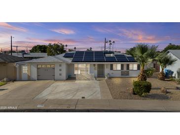 Charming home featuring solar panels, a desert-landscaped front yard, and a freshly painted exterior at 2608 W Columbine Dr, Phoenix, AZ 85029