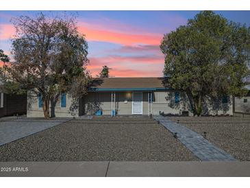 Charming single-story home featuring desert landscaping and a welcoming front porch under a colorful sunset at 2731 N 23Rd Ave, Phoenix, AZ 85009
