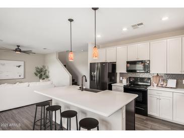 Modern kitchen boasts a spacious island with seating, stainless steel appliances, and stylish pendant lighting at 3900 E Baseline Rd # 137, Phoenix, AZ 85042