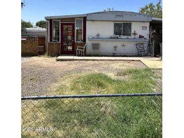 Charming single-story home with a red door and small porch, complemented by a spacious front yard at 4233 E Minton St, Phoenix, AZ 85042