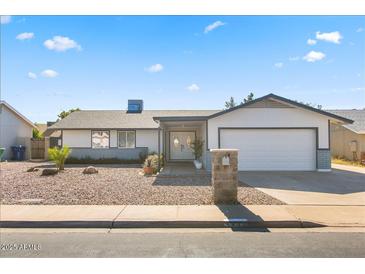 Charming single-story home featuring a manicured front yard and a two-car garage at 4645 E Covina St, Mesa, AZ 85205