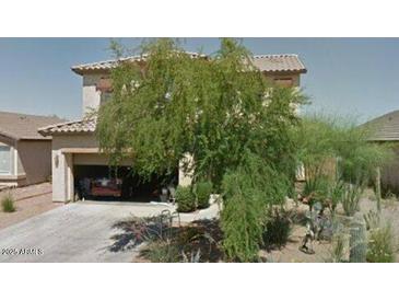 Charming two-story home with a desert landscaped front yard and attached two car garage at 603 N Redwood Ln, Buckeye, AZ 85326
