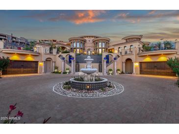 Circular driveway featuring a grand fountain leading to an opulent estate with dual garages at 15536 E Heavenly Vista Trl, Fountain Hills, AZ 85268