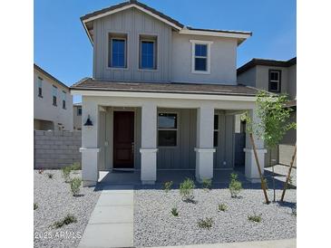Charming two-story home featuring a covered front porch with stone accents and low-maintenance landscaping at 15593 S 180Th Ln, Goodyear, AZ 85338