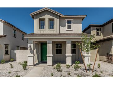 Charming two-story home showcasing a welcoming front porch with a vibrant green door at 15593 S 180Th Ln, Goodyear, AZ 85338