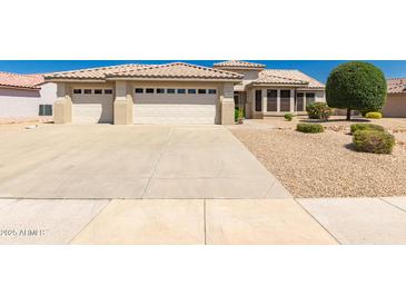Charming single-story home showcasing a well-maintained front yard and three-car garage at 16066 W Sandia Park Dr, Surprise, AZ 85374