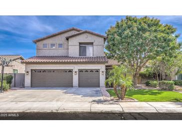Inviting two-story home featuring a three-car garage and lush landscaping at 1697 E Linda Ln, Gilbert, AZ 85234