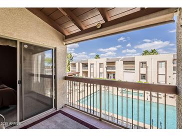 Balcony view showcasing the pool and neighboring building in this well-maintained community at 205 N 74Th St # 227, Mesa, AZ 85207