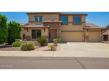 Two-story home featuring stone accents, a three-car garage, and a well-maintained front yard at 26080 N 73Rd Ln, Peoria, AZ 85383