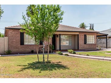 Attractive brick home with a tile roof, covered parking, mature trees, and landscaped front yard at 2807 N 8Th Ave, Phoenix, AZ 85007