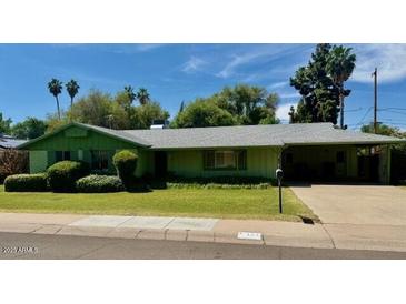 Single-story home with green paint, carport, lush lawn, and established trees at 333 W Seldon Ln, Phoenix, AZ 85021