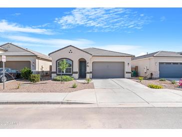 Charming single-story home with a two-car garage, landscaped front yard, and neutral color palette at 40816 W Sunland Dr, Maricopa, AZ 85138