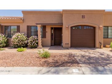 Charming single-story home featuring beautiful landscaping, a private garage, and a welcoming front entry at 4241 N Pebblecreek Pkwy # 7, Goodyear, AZ 85395