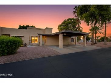 Charming single-story home with a covered carport and well-maintained landscaping at sunset at 446 S 77Th St, Mesa, AZ 85208