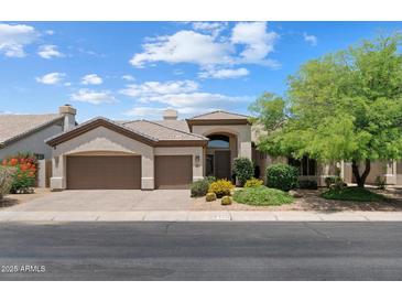Inviting single-story home with a three-car garage and desert landscaping, offering curb appeal and functionality at 6438 E Claire Dr, Scottsdale, AZ 85254