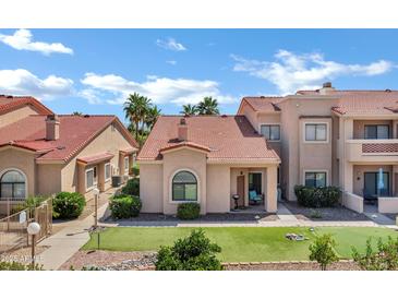 Well-maintained condo exterior with tile roof, desert landscaping, and mini-golf putting green at 16357 E Arrow Dr # 115, Fountain Hills, AZ 85268