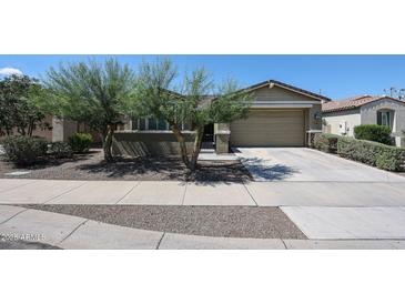 Charming single-story home featuring desert landscaping, a two-car garage, and a welcoming walkway at 16930 W Woodlands Ave, Goodyear, AZ 85338