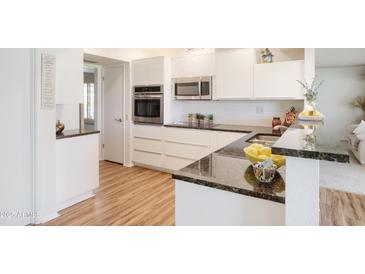 Modern kitchen with stainless steel appliances, sleek countertops, and ample cabinet space at 19030 N Signal Butte Cir, Sun City, AZ 85373