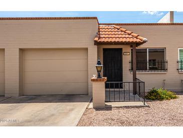 Charming home featuring a decorative tile roof over the front entryway and a single-car garage on the left side at 440 S Parkcrest -- # 145, Mesa, AZ 85206