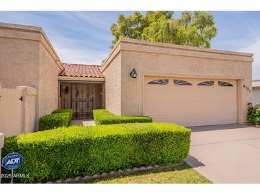Charming single-story home with a two-car garage, desert landscaping, and tile roof at 8171 E Del Caverna Dr, Scottsdale, AZ 85258