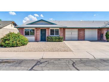 Charming single-story home with brick facade, a green door, and well-maintained landscaping at 9639 W Cinnabar Ave # A, Peoria, AZ 85345
