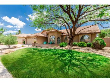 Inviting home with a well-manicured lawn and mature tree shading the front, creating a warm and welcoming curb appeal at 10105 E Larkspur Dr, Scottsdale, AZ 85260