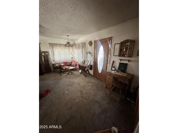Cozy living room featuring vintage furniture and natural light from the large front window at 2102 W Hazelwood St, Phoenix, AZ 85015