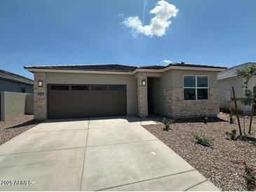 Charming single-story home with stone accents, a well-manicured yard, and a two-car garage at 25165 N 183Rd Dr, Wittmann, AZ 85361