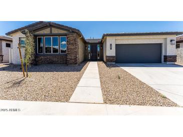 Charming single-story home featuring stone accents, a two-car garage, and desert landscaping at 39640 N Kaden Ln, San Tan Valley, AZ 85140