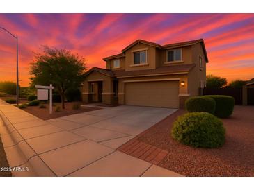 Beautiful two-story home featuring desert landscaping and a two car garage at dusk with colorful skies at 6632 W Saguaro Park Ln, Glendale, AZ 85310