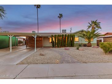 Charming single-story home featuring a covered carport, desert landscaping, and a brick pathway leading to the entrance at 6932 E Latham St, Scottsdale, AZ 85257