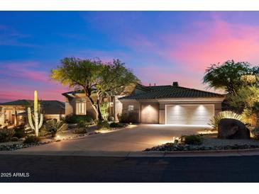Stunning home exterior boasts desert landscaping and a spacious driveway leading to a two-car garage at 9675 E Roadrunner Dr, Scottsdale, AZ 85262