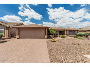 Charming home featuring a large driveway, desert landscaping, and a two-car garage at 10940 E Olla Ave, Mesa, AZ 85212