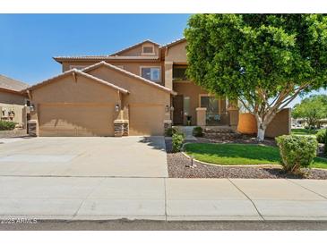 Two-story home with a three-car garage, neutral stucco, tile roof, and well-kept landscaping at 13724 W Luke Ave, Litchfield Park, AZ 85340