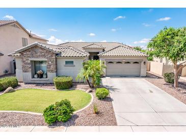 Charming home featuring a well-manicured front yard, stone accents, and a spacious driveway leading to a two-car garage at 2171 E Iris Dr, Chandler, AZ 85286