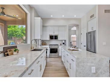 Bright kitchen featuring white cabinetry, stainless steel appliances, and a large window providing natural light at 3624 N Paseo Del Sol --, Mesa, AZ 85207