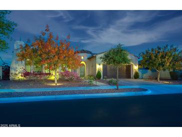 Inviting home exterior featuring beautiful landscaping and a two-car garage at twilight at 4571 N Arbor Way, Buckeye, AZ 85396