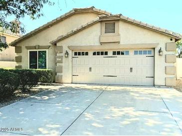 Charming home featuring a two-car garage, manicured landscaping, and a private driveway at 7435 W Trails Dr, Glendale, AZ 85308