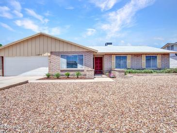 Cozy single-Gathering home with a xeriscaped front yard, brick exterior, two-car garage, and well-maintained landscaping at 13810 N 39Th Ave, Phoenix, AZ 85053