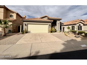 Charming single-Gathering home with a tile roof, desert landscaping, and a two-car garage at 14345 N 101St St, Scottsdale, AZ 85260