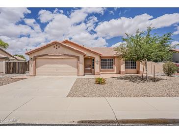 Charming single-story home featuring a well-maintained yard, tile roof, and attached two-car garage at 1660 E Zinnia St, Casa Grande, AZ 85122