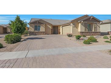 Charming home with a brick paved driveway, stone accents, and manicured landscaping at 2518 E Novak Way, Phoenix, AZ 85042